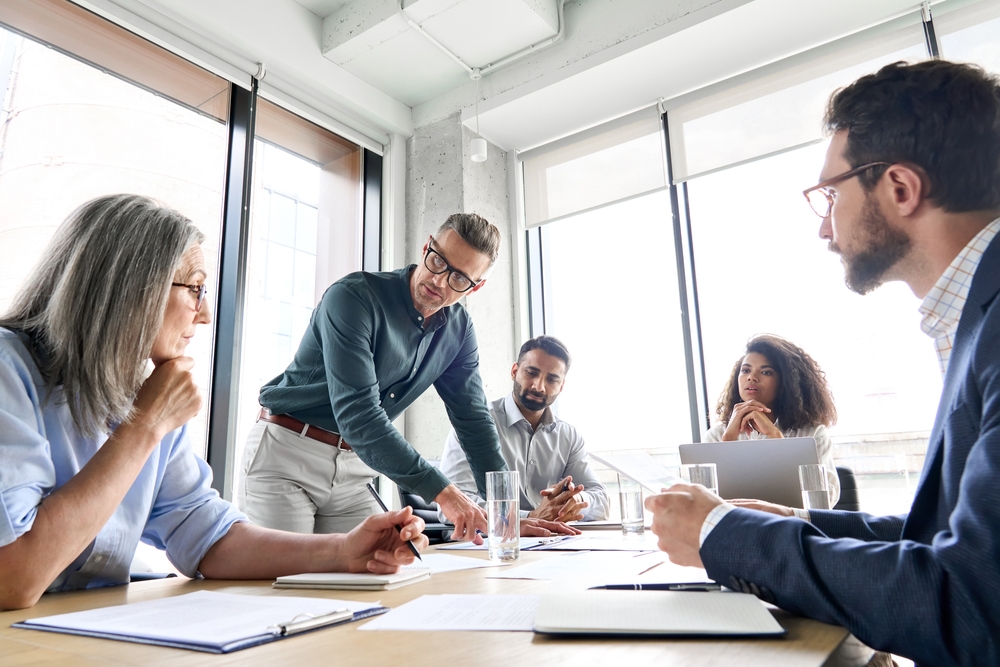 Male mature caucasian ceo businessman leader with diverse coworkers team, executive managers group at meeting