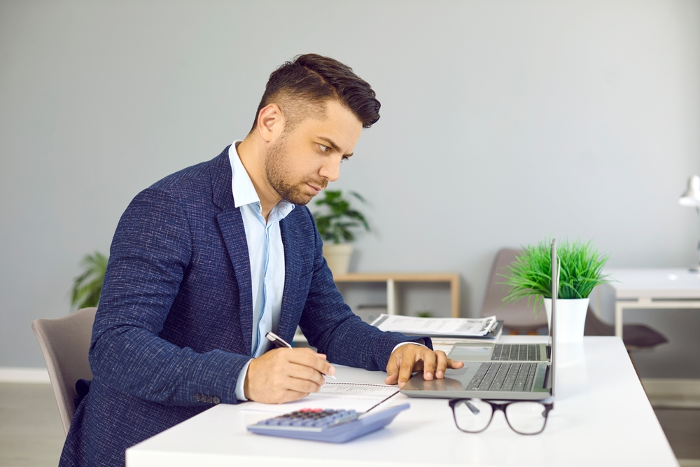 Serious male financial director of business company is engaged in budget analysis and calculations